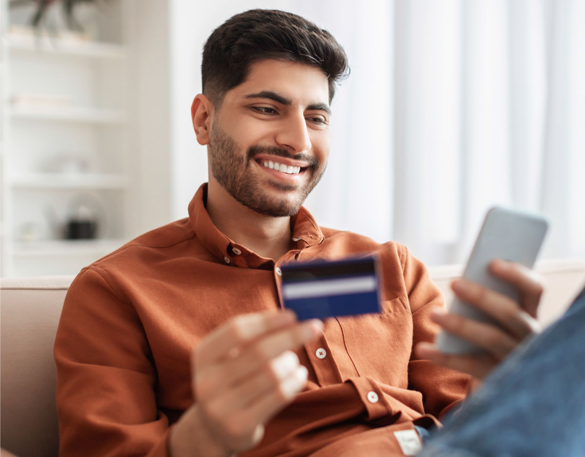 Man looking at credit card and phone